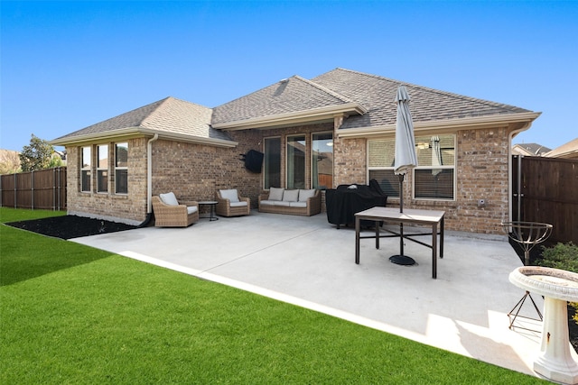 back of property with a lawn, fence, brick siding, and a patio