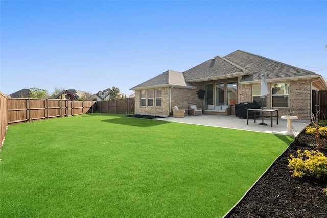 rear view of house with a patio area, a fenced backyard, a shingled roof, an outdoor hangout area, and a lawn