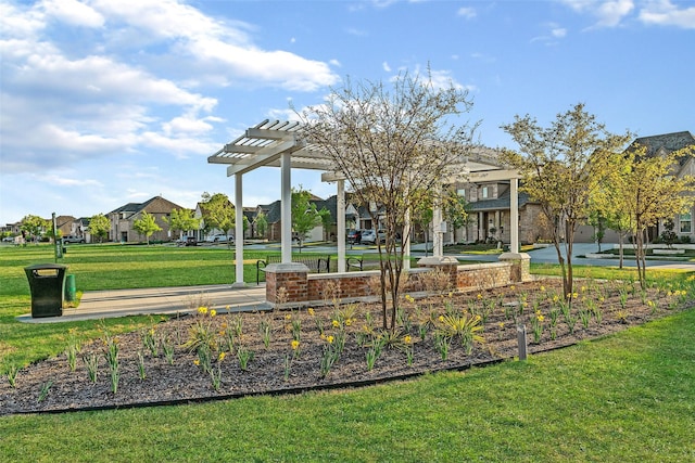 view of community featuring a pergola, a residential view, and a yard