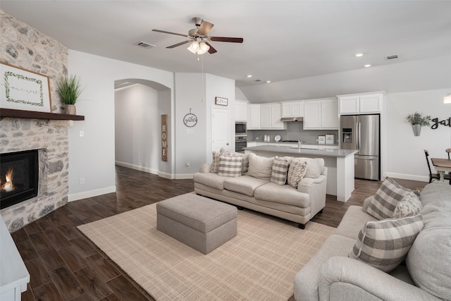 living room with wood finished floors, visible vents, arched walkways, ceiling fan, and recessed lighting