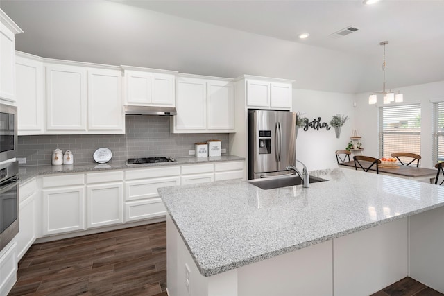kitchen with a sink, under cabinet range hood, stainless steel appliances, visible vents, and decorative backsplash