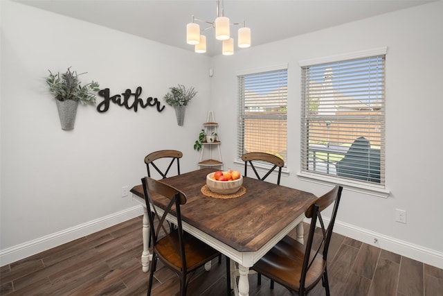 dining area featuring baseboards, a chandelier, and dark wood finished floors