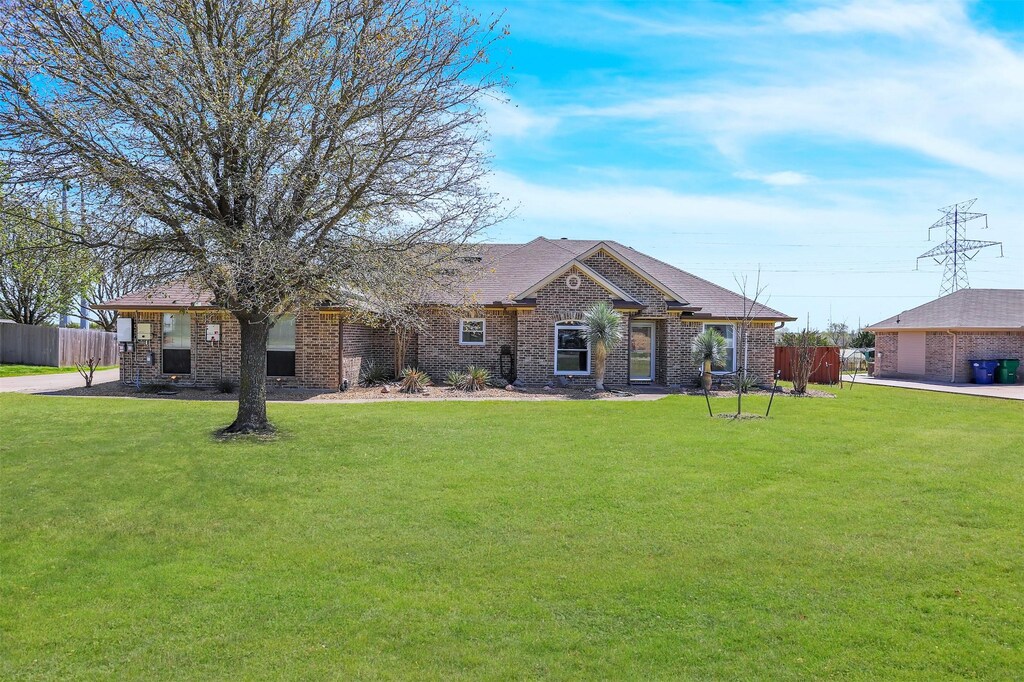 102 Jeremy Dr, Fate, TX 75189 - view of front of house featuring a front yard, fence, brick siding, and a garage