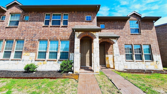 view of front of property featuring stone siding and brick siding