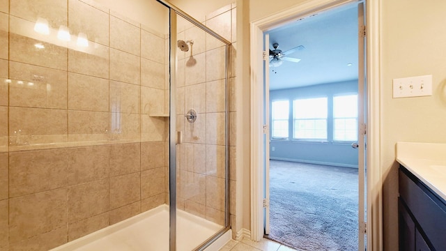full bathroom featuring vanity, baseboards, ceiling fan, and a shower stall