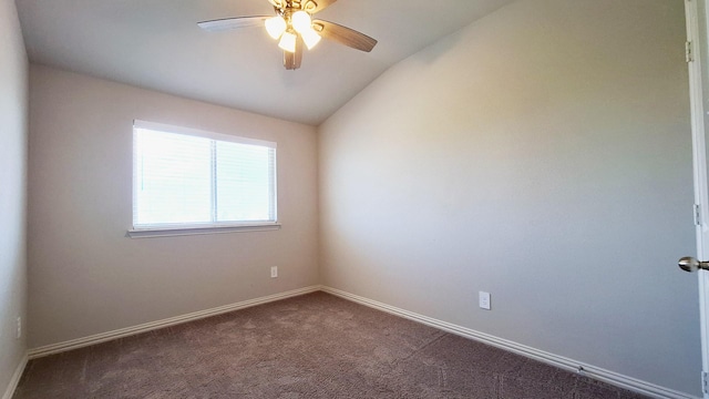 spare room with baseboards, dark colored carpet, vaulted ceiling, and ceiling fan