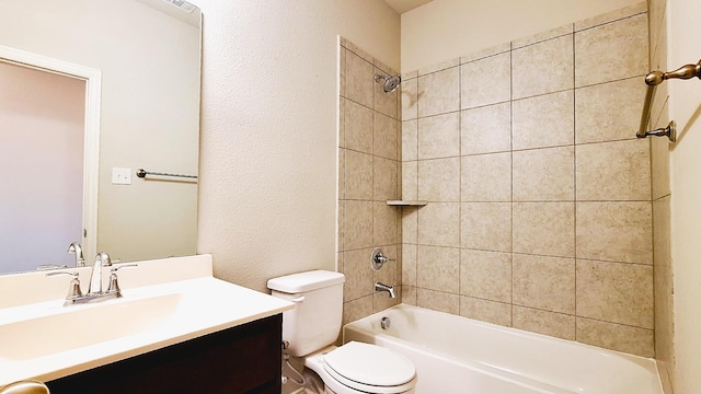 bathroom with toilet, vanity, a textured wall, and bathtub / shower combination