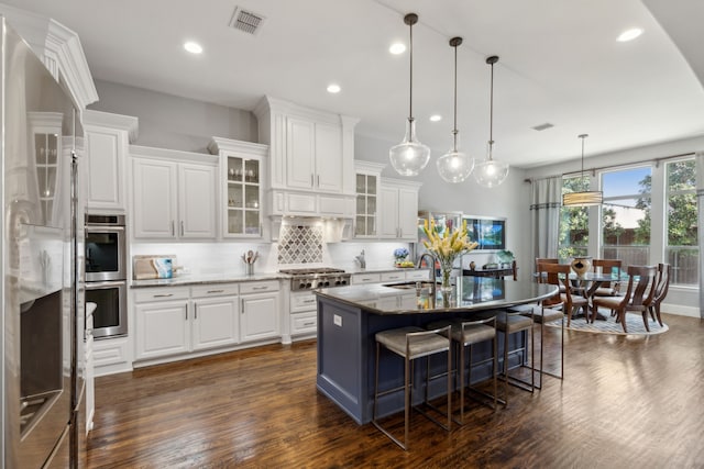 3960 Briar Tree Ln, Frisco, TX 75034 - kitchen with appliances with stainless steel finishes, recessed lighting, white cabinetry, tasteful backsplash, and a kitchen breakfast bar