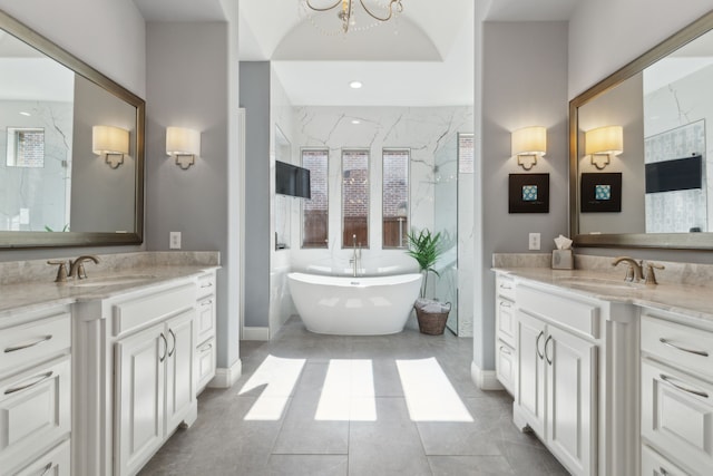 3960 Briar Tree Ln, Frisco, TX 75034 - bathroom with two vanities, a freestanding tub, and healthy amount of natural light