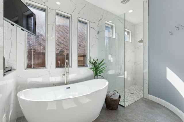 3960 Briar Tree Ln, Frisco, TX 75034 - bathroom with a freestanding tub, marble tiled flooring, a marble finish shower, tile walls, and baseboards