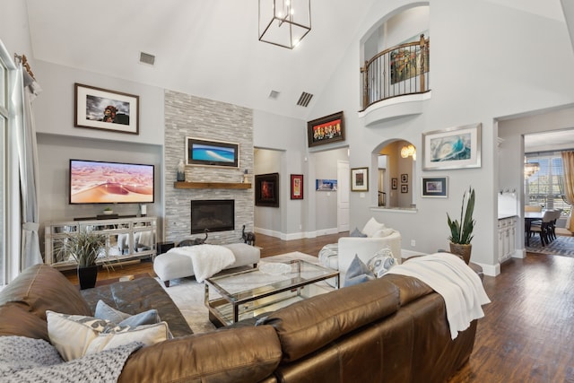 3960 Briar Tree Ln, Frisco, TX 75034 - living room featuring dark wood-style floors, high vaulted ceiling, a stone fireplace, baseboards, and a chandelier