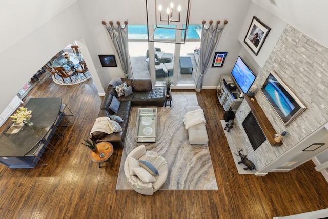 3960 Briar Tree Ln, Frisco, TX 75034 - living area featuring a glass covered fireplace, wood finished floors, baseboards, and a chandelier