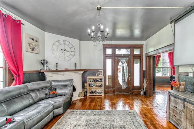 foyer featuring hardwood / wood-style floors, baseboards, and a notable chandelier
