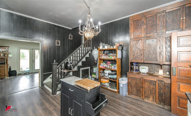 interior space featuring wooden walls, a notable chandelier, stairway, and dark wood finished floors