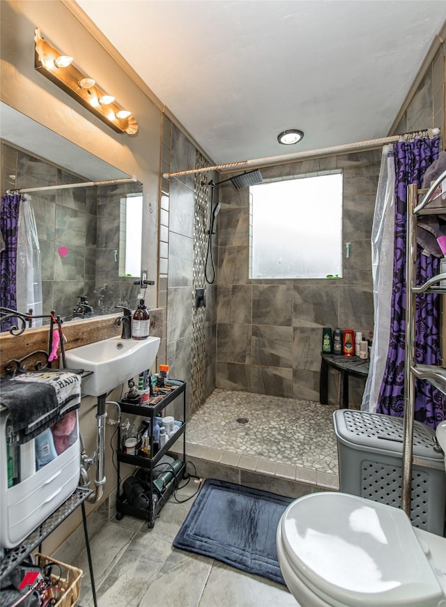 full bathroom featuring a tile shower and tile walls
