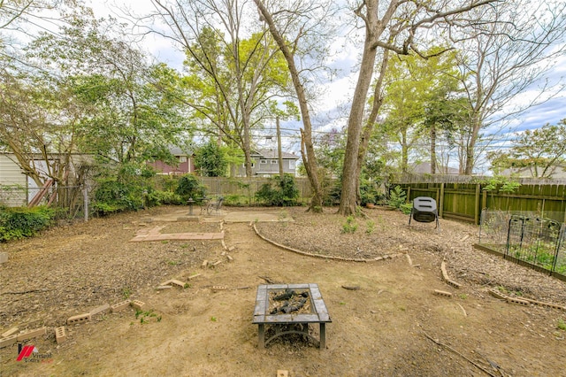 view of yard featuring a fire pit and a fenced backyard