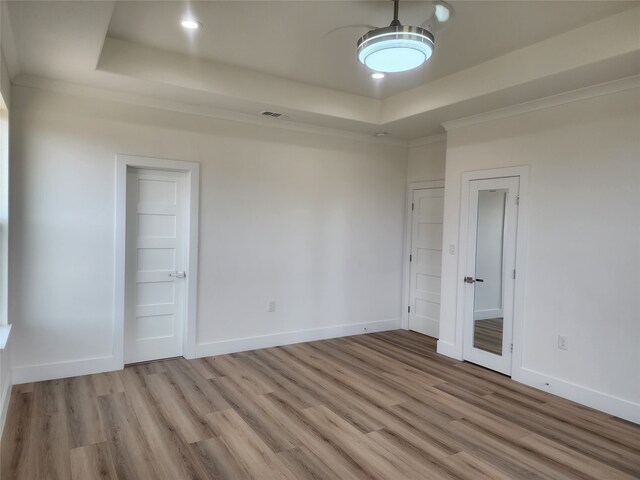 144 Shawnee Trl, Pottsboro, TX 75076 - spare room with light wood-type flooring, baseboards, a tray ceiling, and visible vents