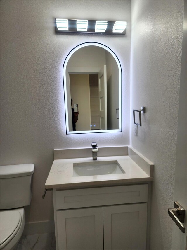 144 Shawnee Trl, Pottsboro, TX 75076 - half bathroom with baseboards, marble finish floor, vanity, and toilet