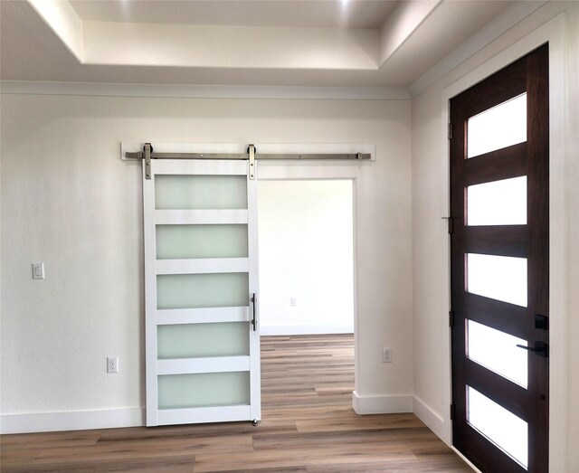 144 Shawnee Trl, Pottsboro, TX 75076 - foyer entrance featuring a barn door, a raised ceiling, wood finished floors, and baseboards
