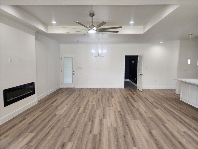 144 Shawnee Trl, Pottsboro, TX 75076 - unfurnished living room with a tray ceiling, light wood-style flooring, baseboards, and ceiling fan