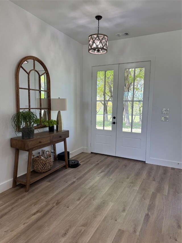 entryway with visible vents, baseboards, french doors, and wood finished floors
