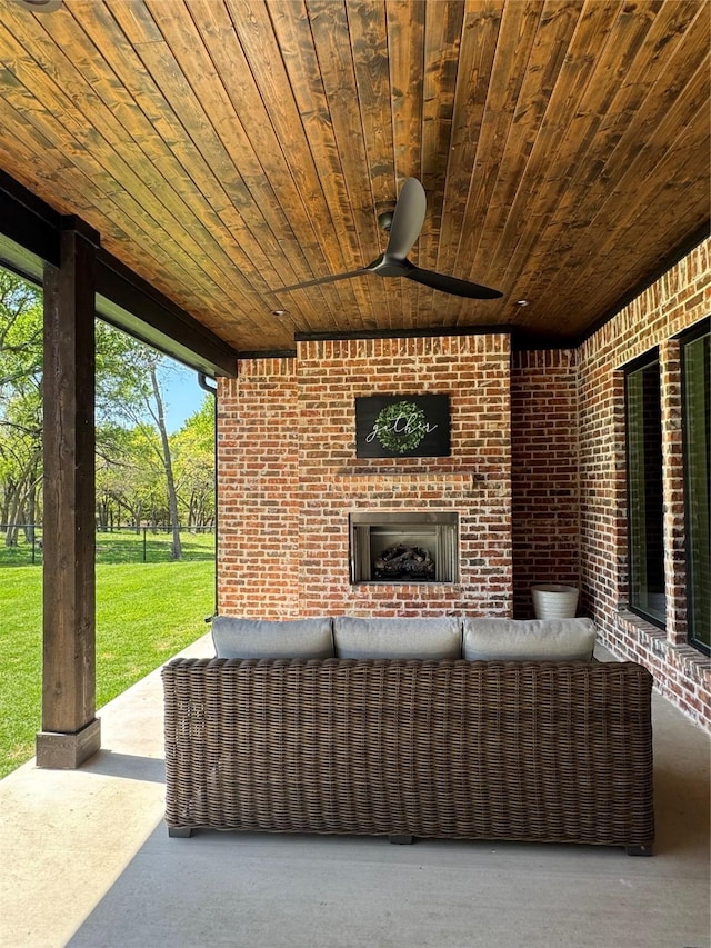 view of patio / terrace with an outdoor living space with a fireplace and a ceiling fan