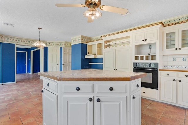 3709 Windmill Hill St, Waco, TX 76710 - kitchen with visible vents, a kitchen island, open shelves, ceiling fan with notable chandelier, and black oven