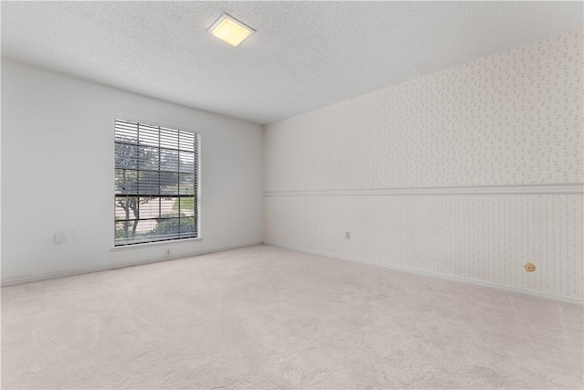 3709 Windmill Hill St, Waco, TX 76710 - spare room with a wainscoted wall, a textured ceiling, wallpapered walls, and carpet floors