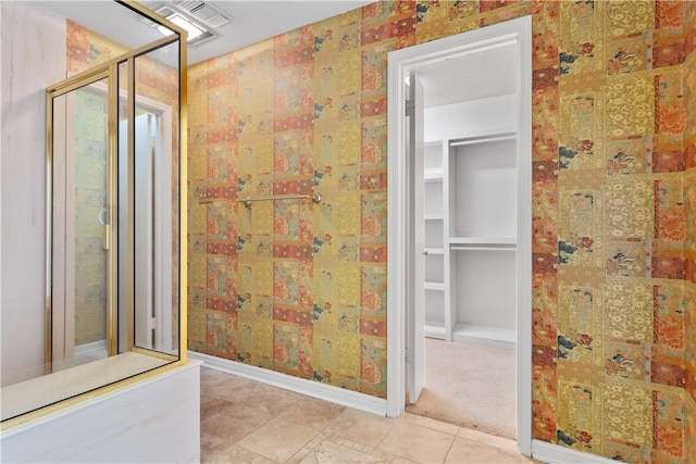 3709 Windmill Hill St, Waco, TX 76710 - bathroom featuring baseboards, a walk in closet, a walk in shower, and tile patterned flooring