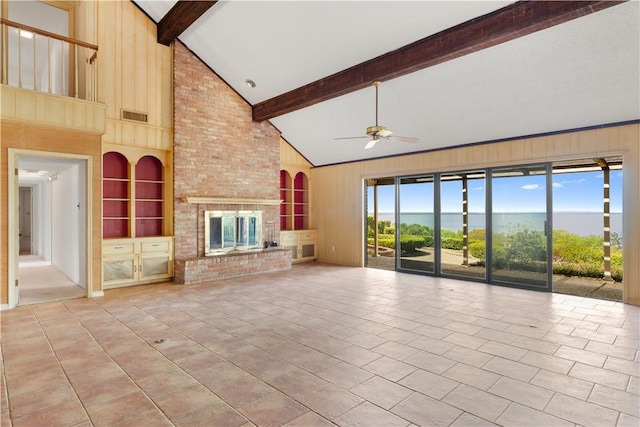3709 Windmill Hill St, Waco, TX 76710 - unfurnished living room with wood walls, beam ceiling, light tile patterned floors, and a ceiling fan