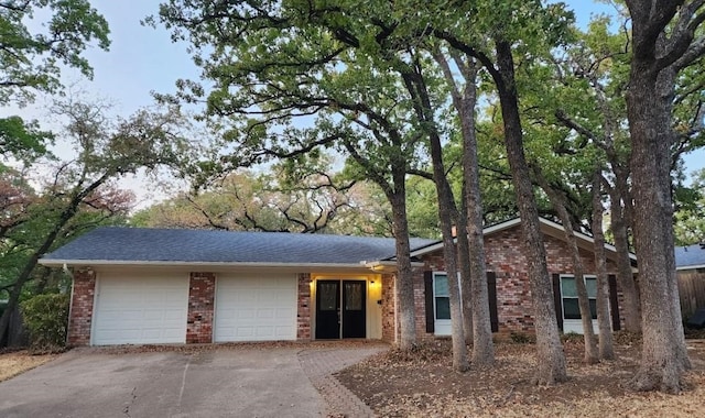 ranch-style house featuring brick siding, a garage, and concrete driveway