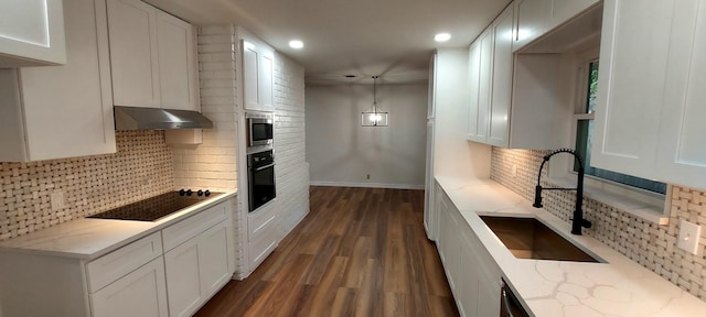 kitchen featuring a sink, white cabinetry, under cabinet range hood, black appliances, and dark wood-style flooring