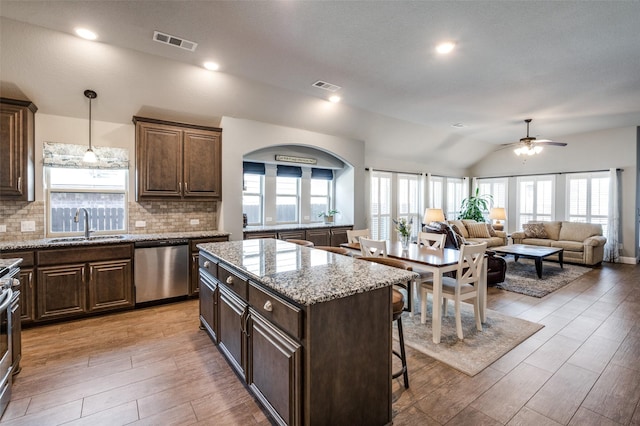 1001 Hodge St, Mckinney, TX 75071 - kitchen with appliances with stainless steel finishes, a sink, vaulted ceiling, backsplash, and dark brown cabinets