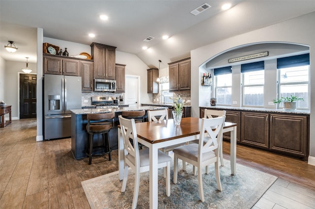 1001 Hodge St, Mckinney, TX 75071 - dining space featuring vaulted ceiling, dark wood-type flooring, arched walkways, and recessed lighting