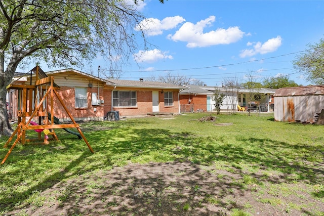 rear view of property with a yard, brick siding, and a playground