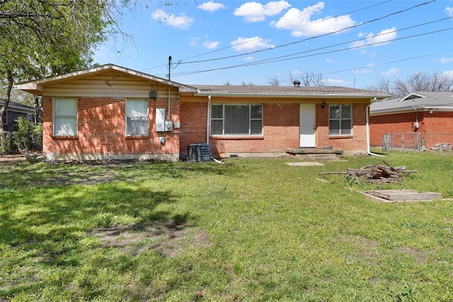 view of front facade featuring a front yard, fence, and brick siding