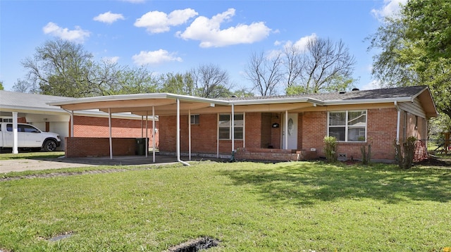 ranch-style house with a front yard, brick siding, an attached carport, and driveway