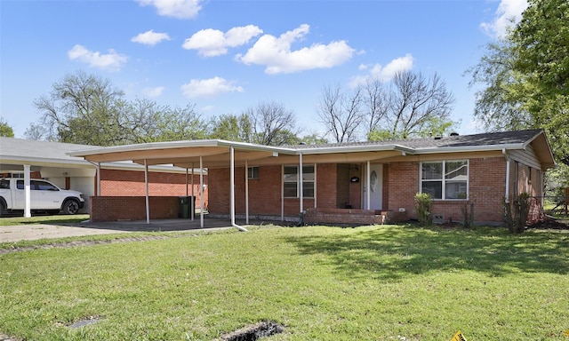 single story home with a front yard, brick siding, a carport, and driveway