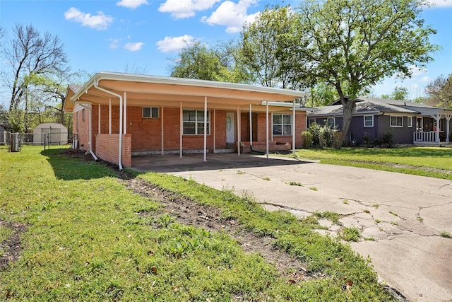 view of front facade featuring a carport, driveway, a front yard, and brick siding