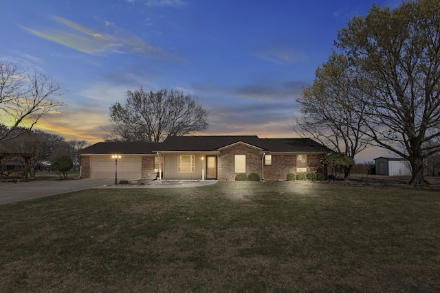 ranch-style house featuring driveway, a garage, and a lawn