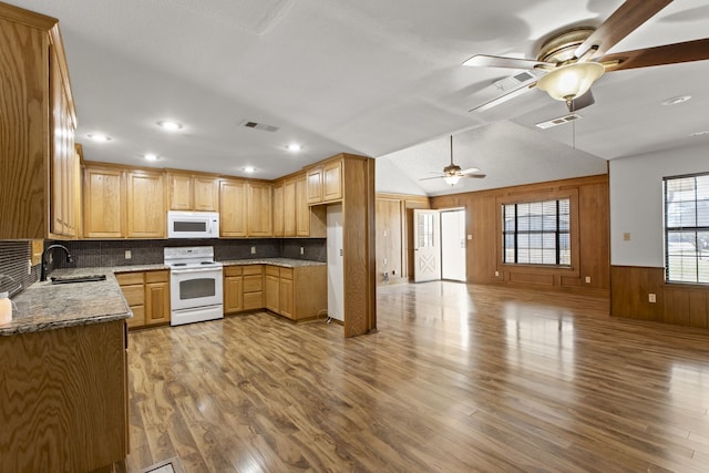 kitchen featuring white appliances, wood finished floors, a ceiling fan, a sink, and open floor plan