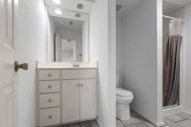 full bath featuring a stall shower, tile patterned floors, toilet, and vanity