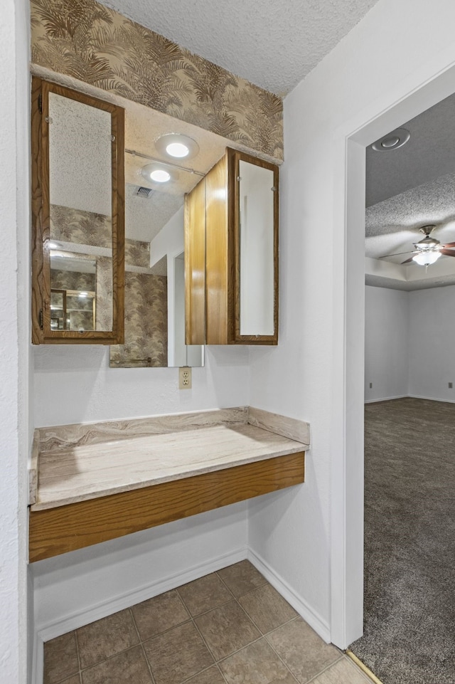 bathroom with tile patterned floors, baseboards, ceiling fan, and a textured ceiling