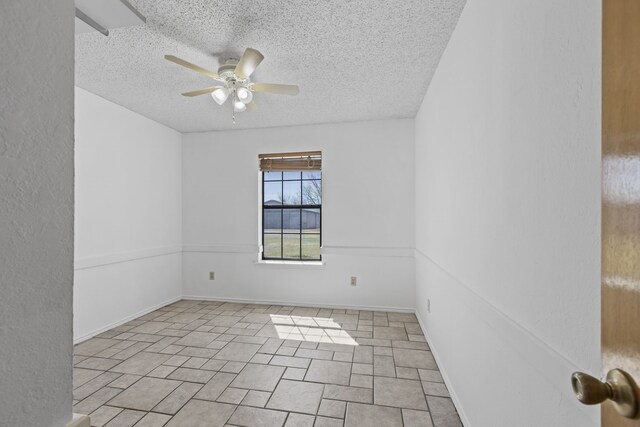 unfurnished room with a textured ceiling, baseboards, and a ceiling fan