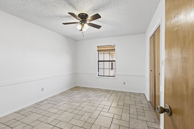 unfurnished room featuring a textured ceiling, baseboards, and a ceiling fan