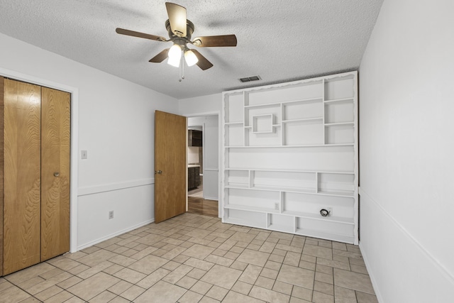 unfurnished bedroom with visible vents, ceiling fan, and a textured ceiling