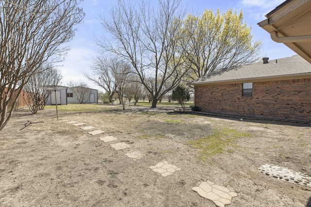view of yard featuring an outdoor structure and a storage shed