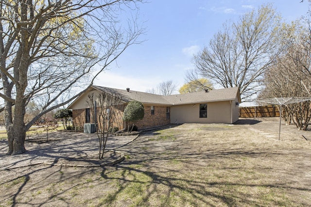 rear view of property with fence and brick siding