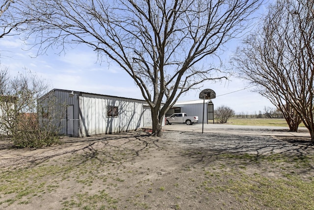 view of yard with dirt driveway, an outbuilding, and an outdoor structure