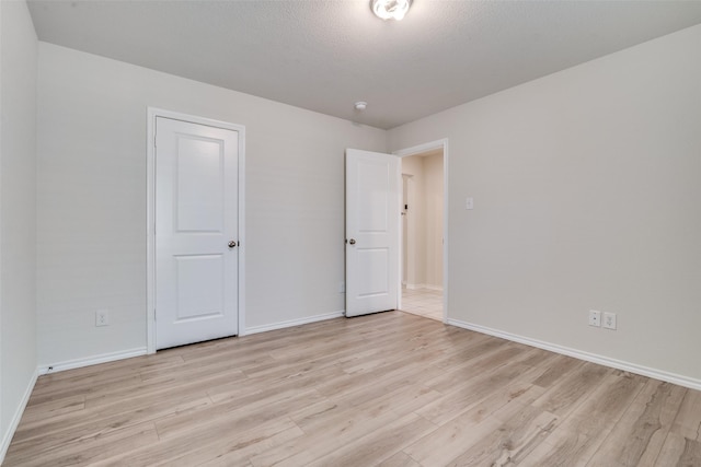 2430 Rosharon Dr, Forney, TX 75126 - unfurnished bedroom featuring baseboards, a textured ceiling, and light wood-style flooring